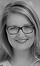 Cornelia Ast Porträt einer lächelnden Frau mit Brille und langen, glatten Haaren. Der Hintergrund ist unscharf, was den Fokus auf ihr freundlich strahlendes Gesicht lenkt.